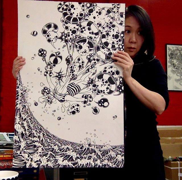 Yuko Shimizu holding her artwork